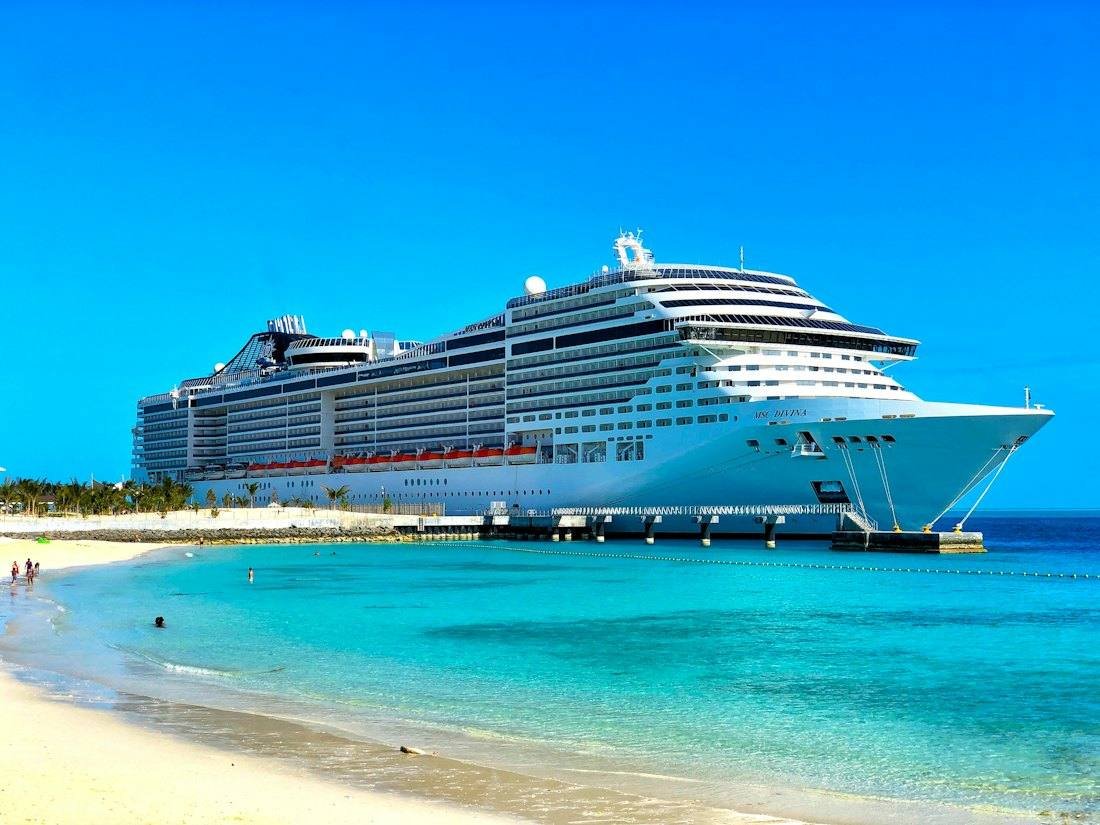 Cruise ship docked by a tropical beach